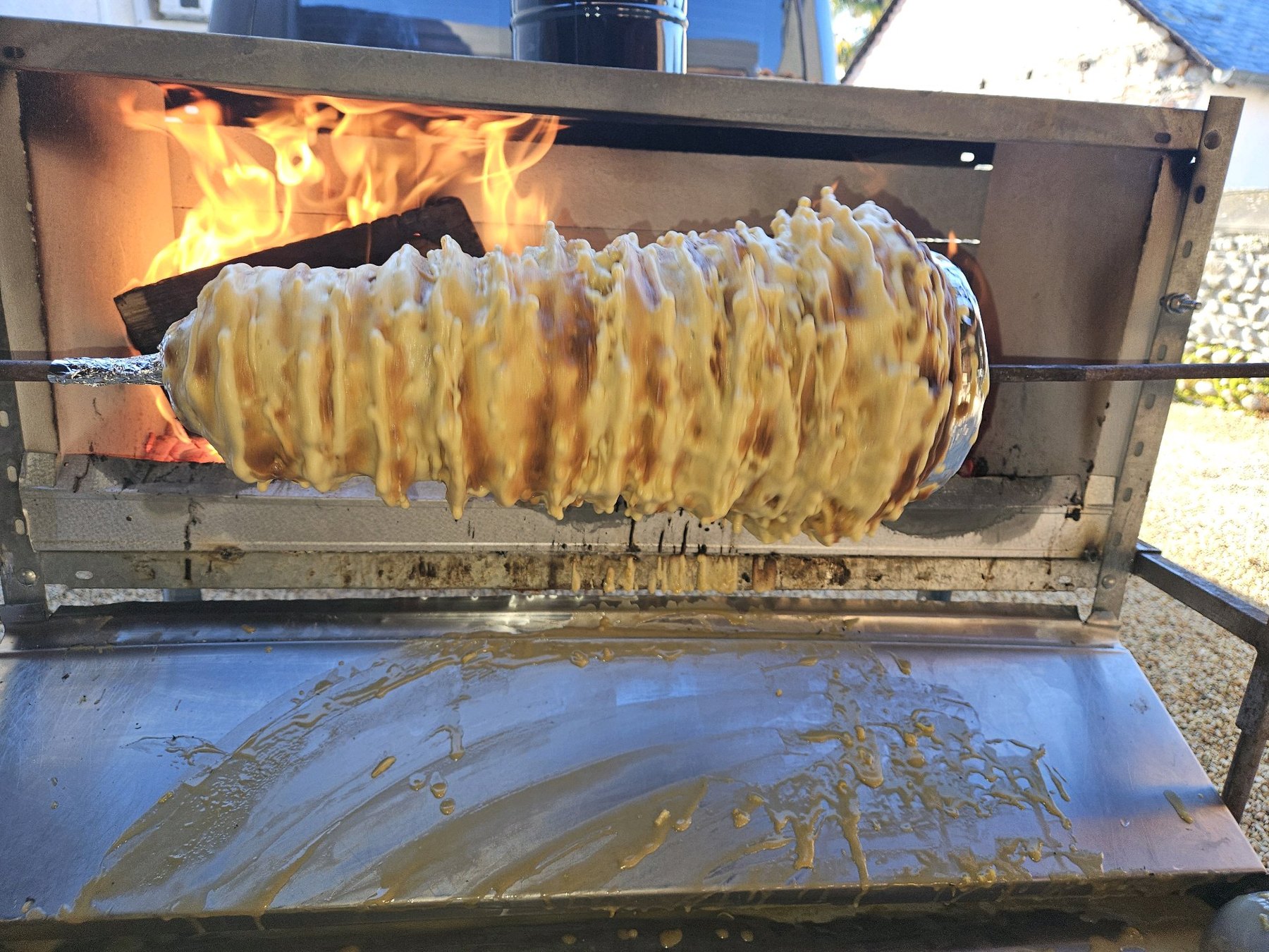 La pâte tourne devant le feu pendant la cuisson du gâteau à la broche